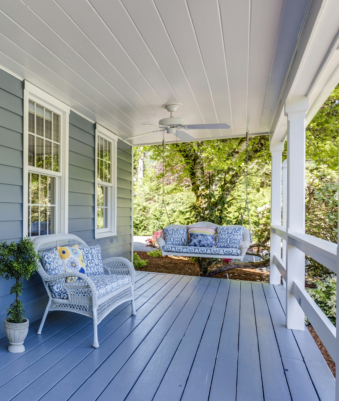A welcoming covered porch with wicker chairs and a porch swing